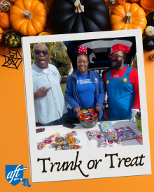snapshot of adults at a halloween trunk or treat event with candy and books for kids